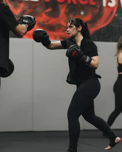 Kickboks antrenmanında yumruk atan kadın sporcu