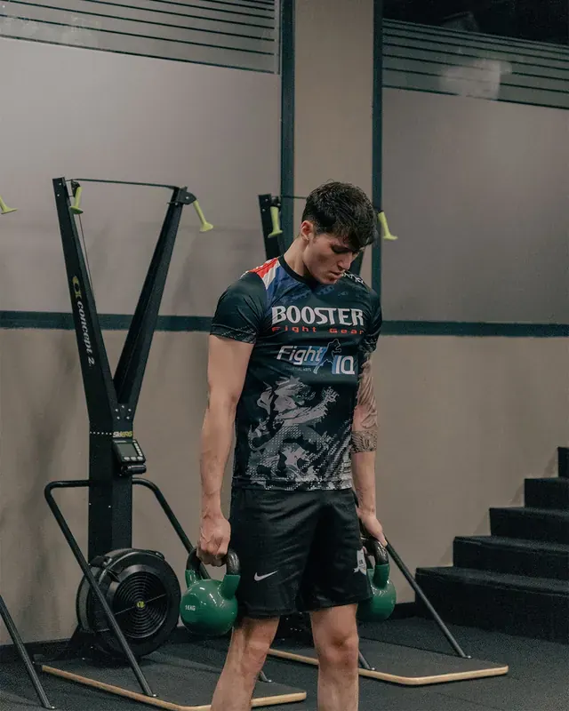 İki elinde kettlebell ile antrenman yapan genç erkek